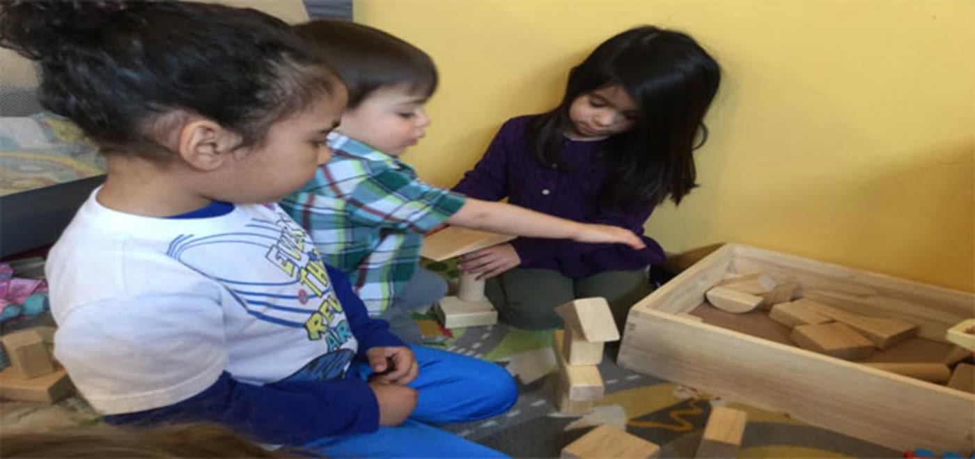 Children playing together with wooden building blocks at Little Bird